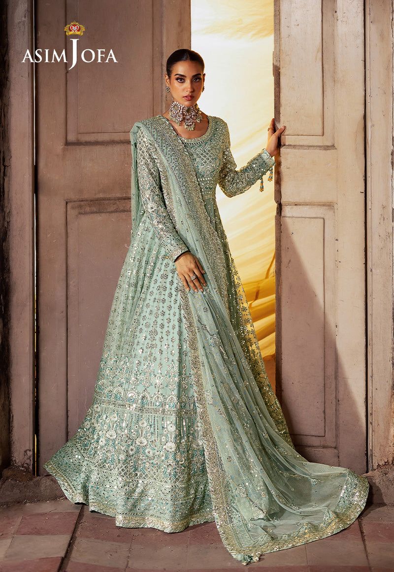 Asim Jofa Maxi Frock Pista green embroidered Asim Jofa dress standing in a doorway.