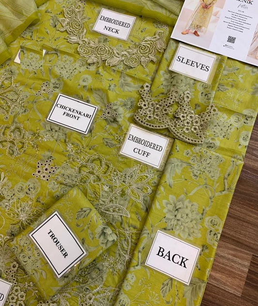 Yellow fabric with embroidered patterns and labels on a wooden surface