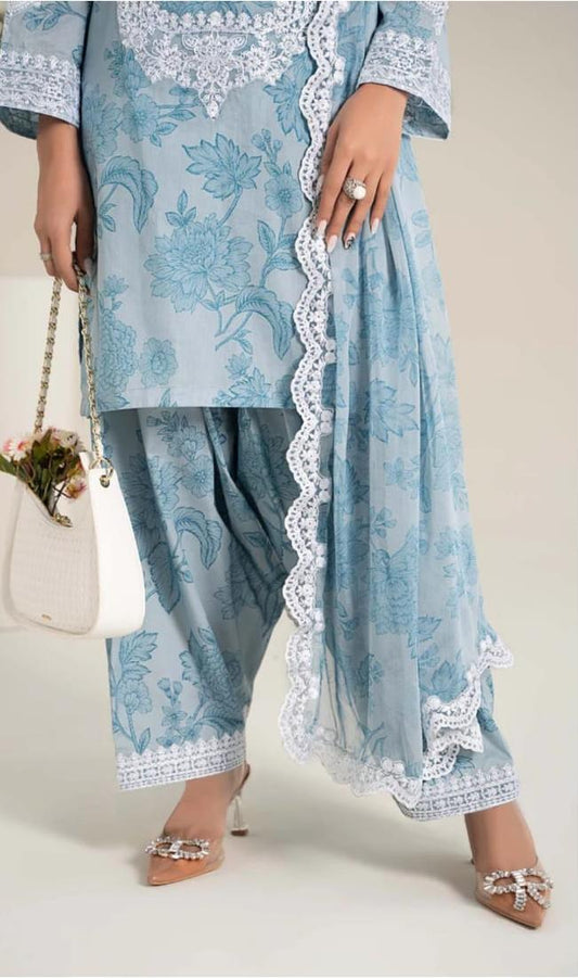 Light blue embroidered traditional outfit with white lace details on a neutral background