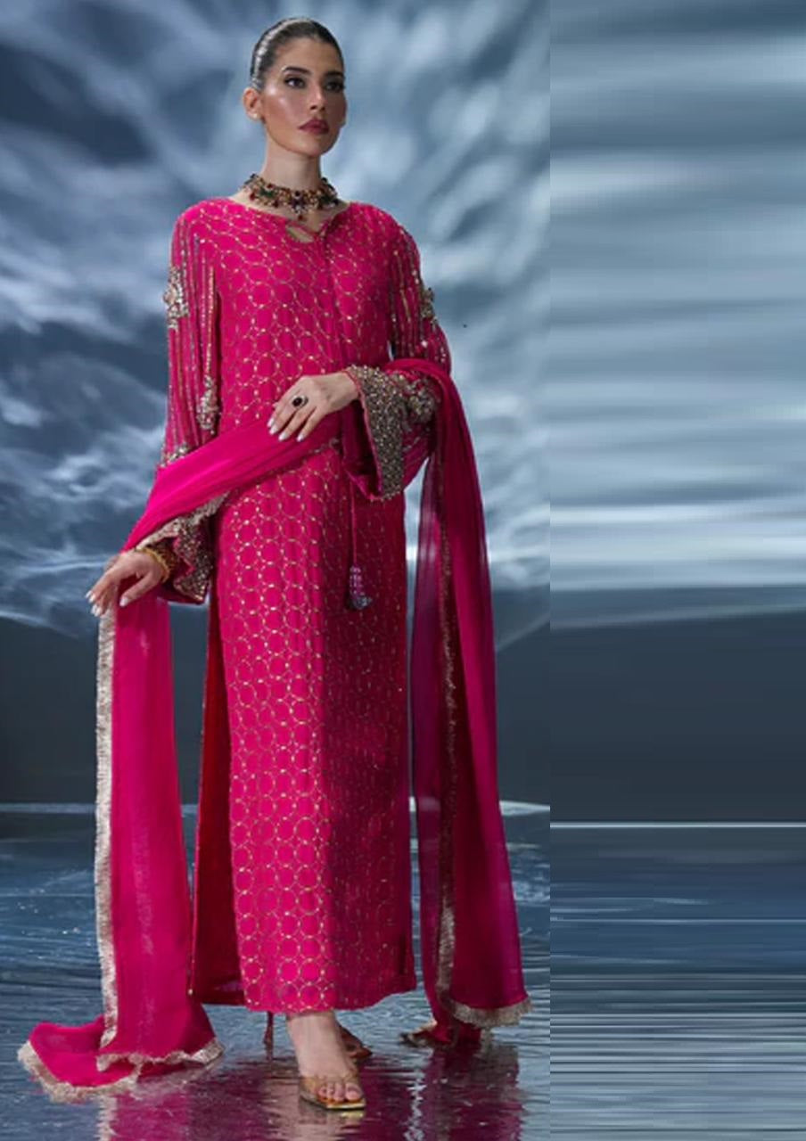 Amave in a pink traditional outfit with a matching dupatta against a reflective background