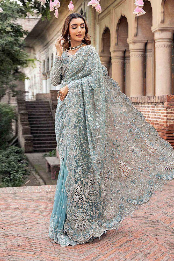 MAria b Beautiful ew Saree 2025 Net Fabriclight blue saree with intricate patterns standing outdoors.