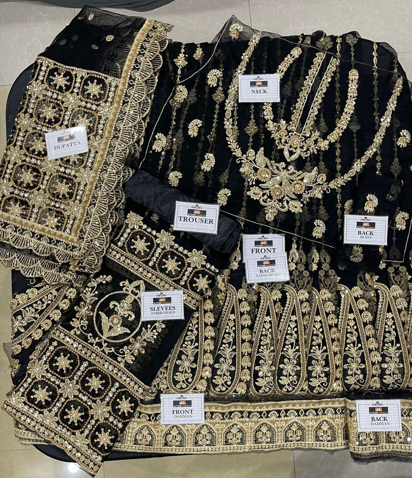 Black embroidered saree with gold details on a flat surface
