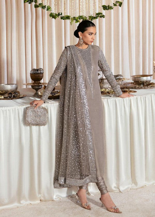 Woman in a silver sequin outfit standing in front of a decorated table with white drapes.