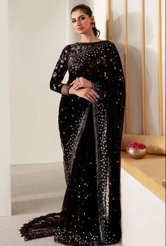 Woman wearing a black sequin saree in an elegant setting.