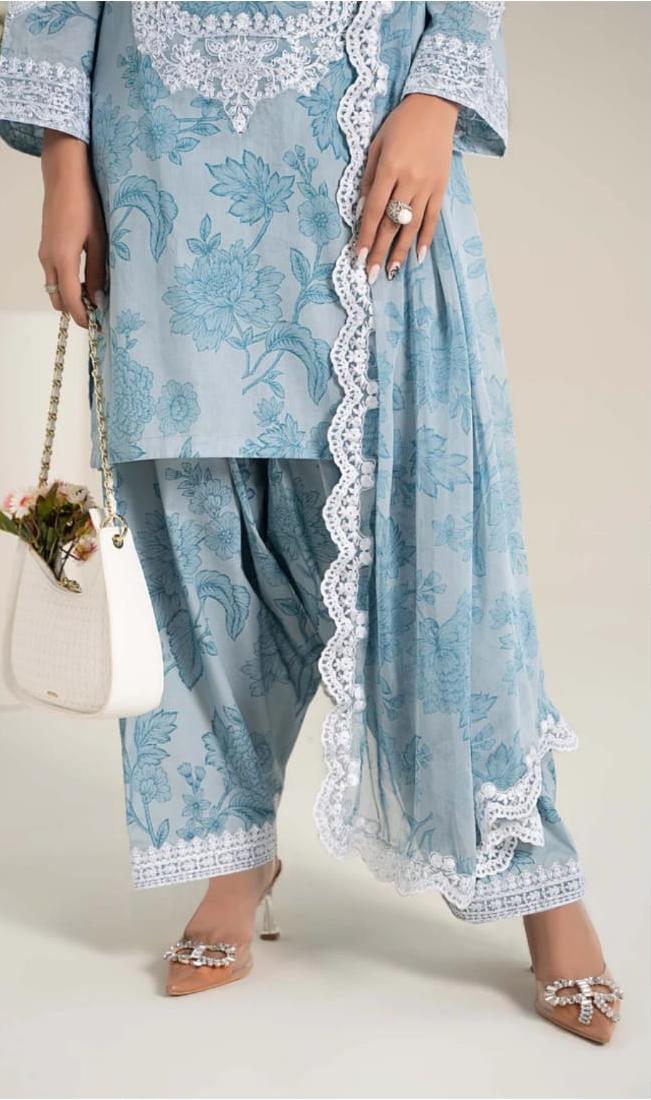 Light blue embroidered traditional outfit with white lace details on a neutral background