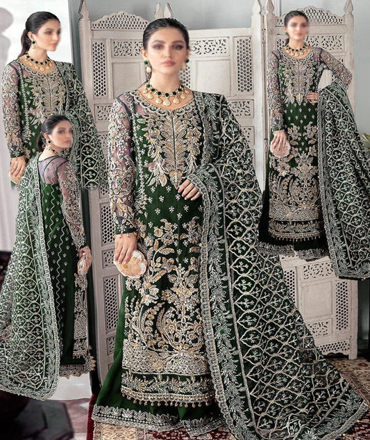 Gulaal Qayinaat Emb Bridal Soft Net Wedding & Party Wear Dress 2025 Woman in a green and silver embroidered traditional outfit standing in front of a mirror.