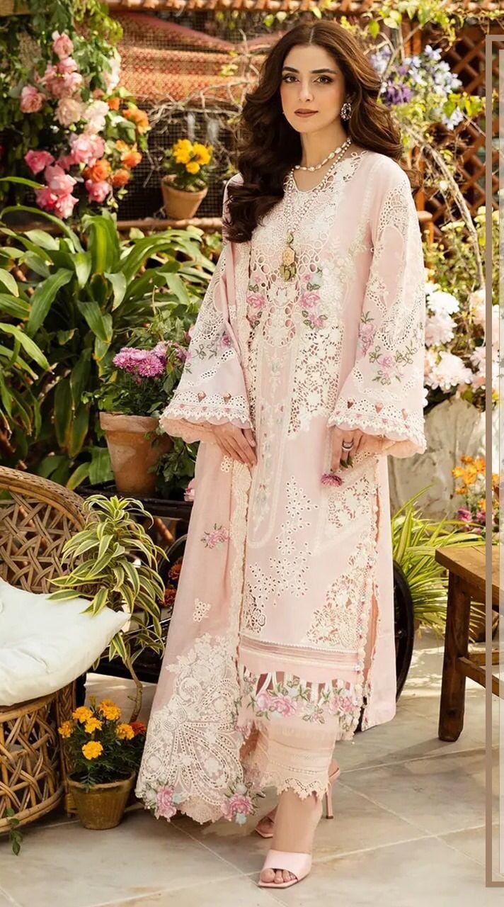 Elaaf Chikankari Pink  in a floral dress standing in a garden with flowers and plants.