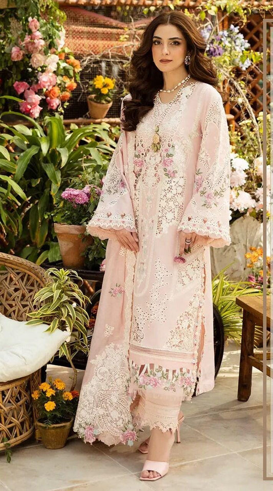 Elaaf Chikankari Pink  in a floral dress standing in a garden with flowers and plants.